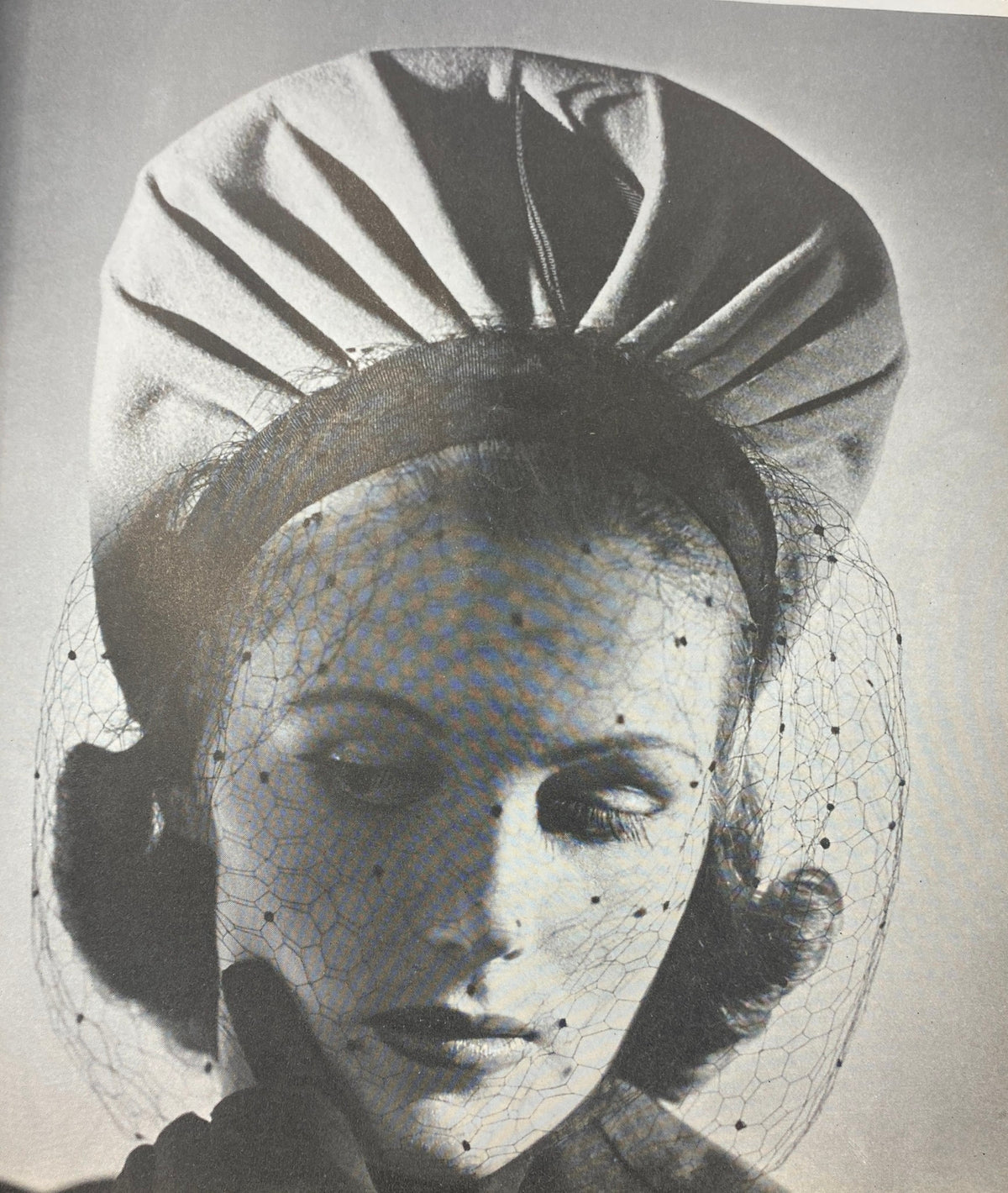 Close-up of a model wearing a fashionable hat and veils from Mademoiselle Magazine July 1940, reflecting vintage 1940s beauty style.