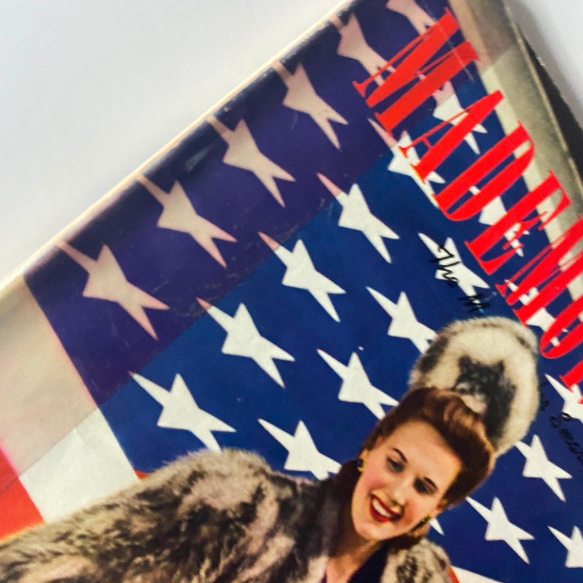 Close-up of Mademoiselle Magazine October 1940 cover, highlighting a woman wearing a fur coat with the American flag design in the background.