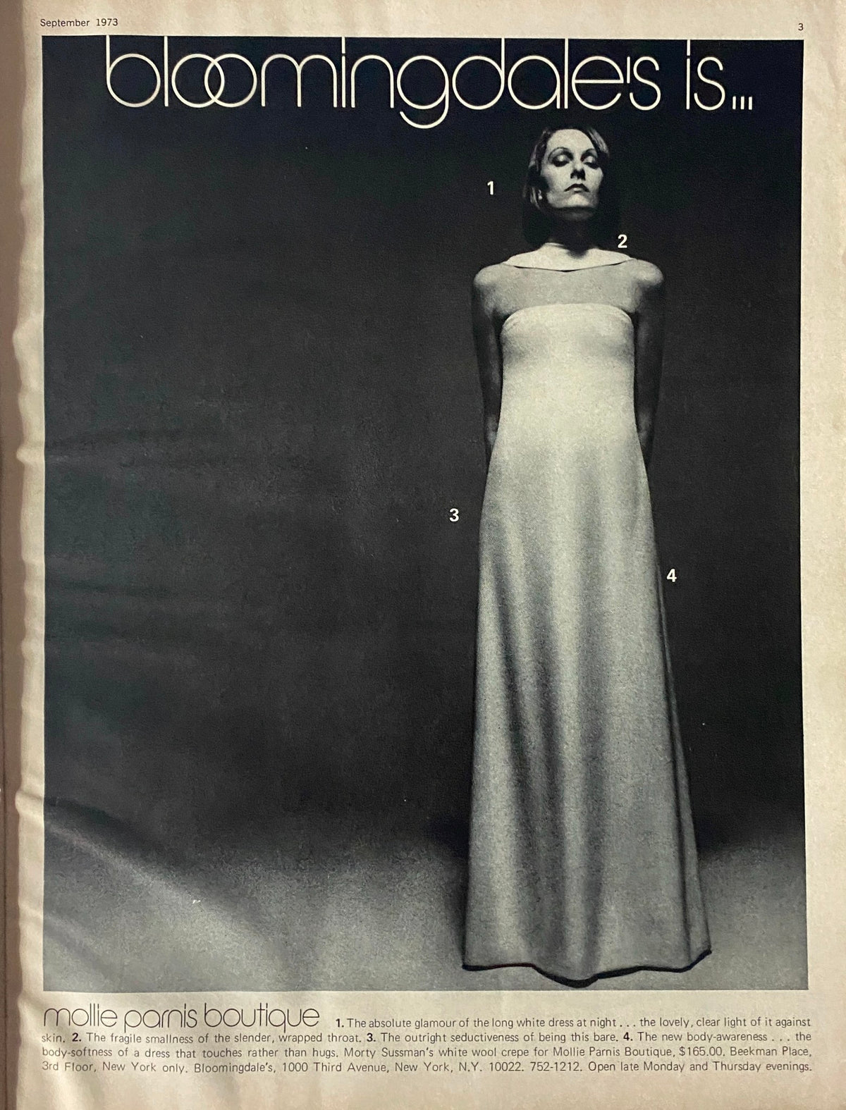 Black and white fashion advertisement within Harper's Bazaar Magazine September 1973, featuring a model in a minimalist dress, indicative of the fashion aesthetics of the era.