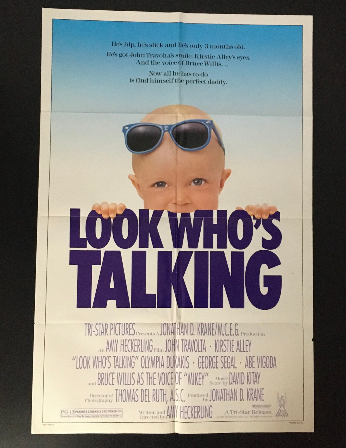 1989 Look Who's Talking 41" x 27" Original Movie Poster featuring John Travolta, showcasing a smiling infant with sunglasses, promoting the film's comedic elements.