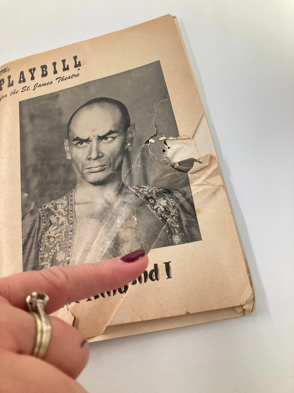 Close-up view of the 1953 Playbill from the St. James Theatre featuring Yul Brynner in The King and I, highlighting the vintage details and wear characteristic of its history.