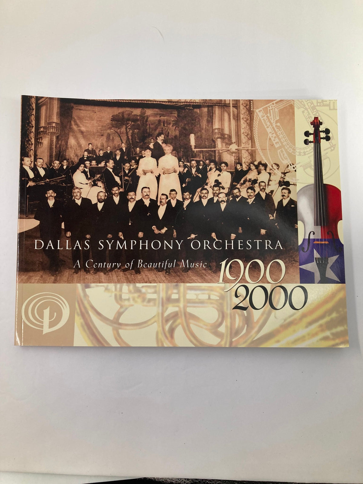 Cover of the 2000 Program Souvenir Dalla Symphony Orchestra titled 'A Century of Beautiful Music', featuring an orchestra and a violin graphic.