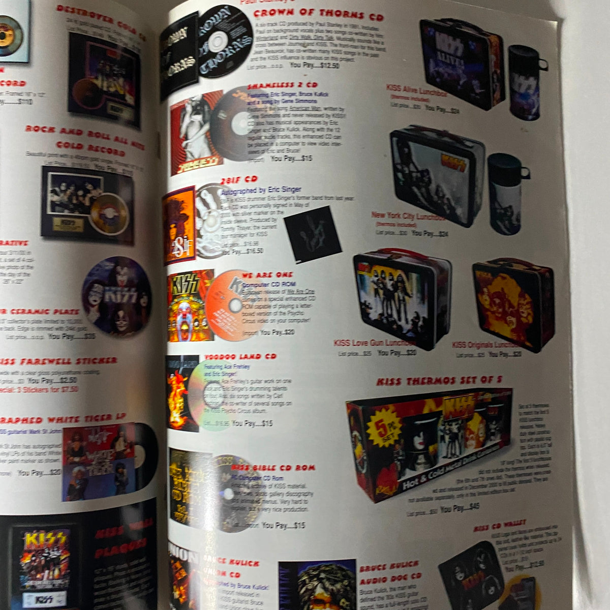 Another page from the KISS Museum.com Catalog Fall 2002 featuring various KISS collectibles such as CDs, lunch boxes, and memorabilia like the KISS Thermos Set of 5.