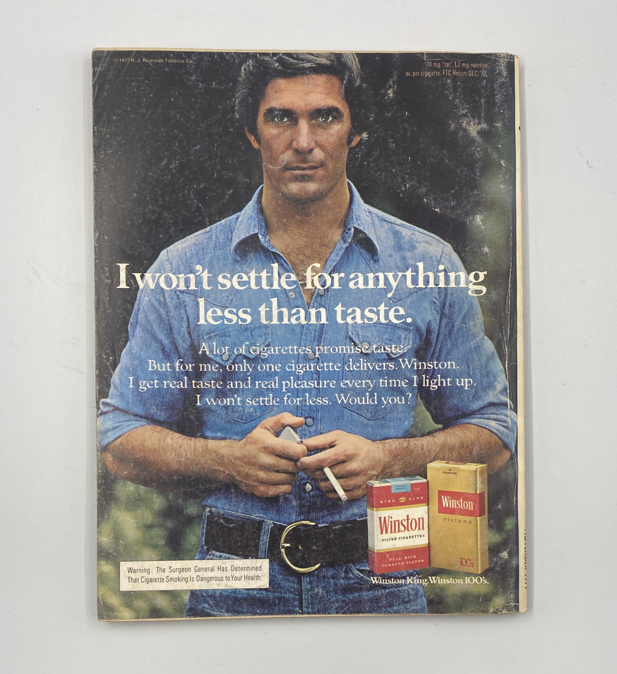 Esquire Magazine November 1977 featuring an advertisement for Winston cigarettes, showcasing a man in a blue shirt holding a cigarette with the text: 'I won't settle for anything less than taste.'