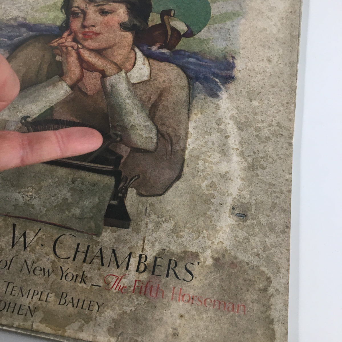 Detail of the cover of VTG McCall's Magazine April 1930 showcasing the artistic depiction of a woman, with emphasis on the title 'The Fifth Horseman' by Robert Chambers.