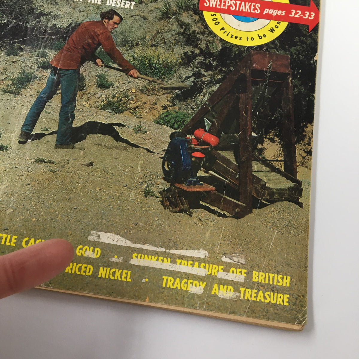 Close-up of the cover of VTG True Treasure Magazine February 1971, highlighting the featured articles on lost gold and treasures, with a person in the background engaged in treasure hunting.