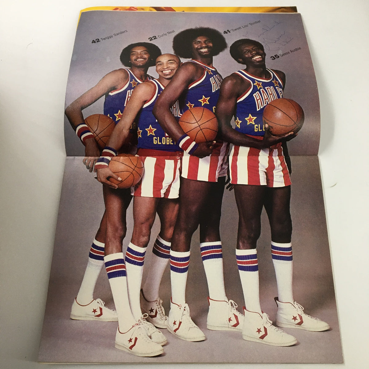 1980 Harlem Globertrotters The Trotters on Tour image of four team members posing proudly in their colorful uniforms, highlighting the spirit and athleticism of the famous Harlem Globertrotters.