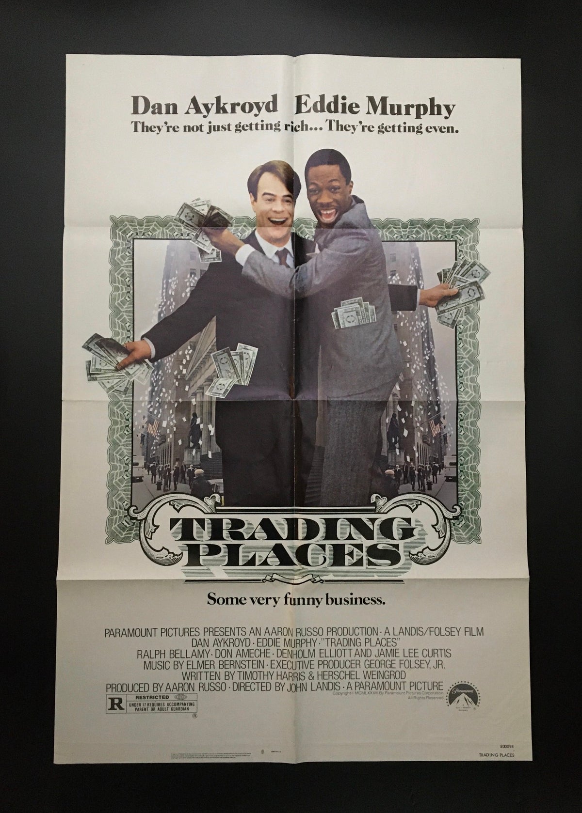 1983 Trading Places 41" x 27" Original Movie Poster featuring Eddie Murphy and Dan Aykroyd, showcasing a humorous scene with money and a city backdrop.
