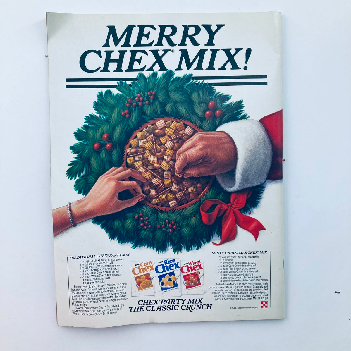 Vintage advertisement for Merry Chex Mix featuring hands reaching for a bowl of Chex Party Mix, surrounded by a festive wreath, from the Saturday Evening Post Magazine December 1988. This ad depicts holiday spirit and traditional snack recipes.