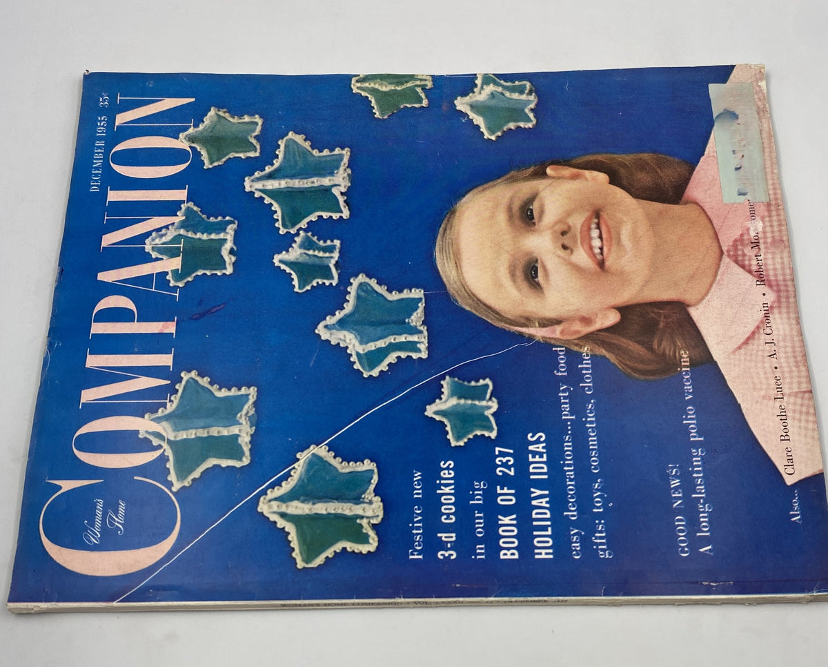 Woman’s Home Companion Magazine December 1955 cover showcasing festive holiday ideas, 3-d cookies, and a cheerful girl surrounded by decorative snowflake elements. Highlights articles on gifts, food, and beauty.