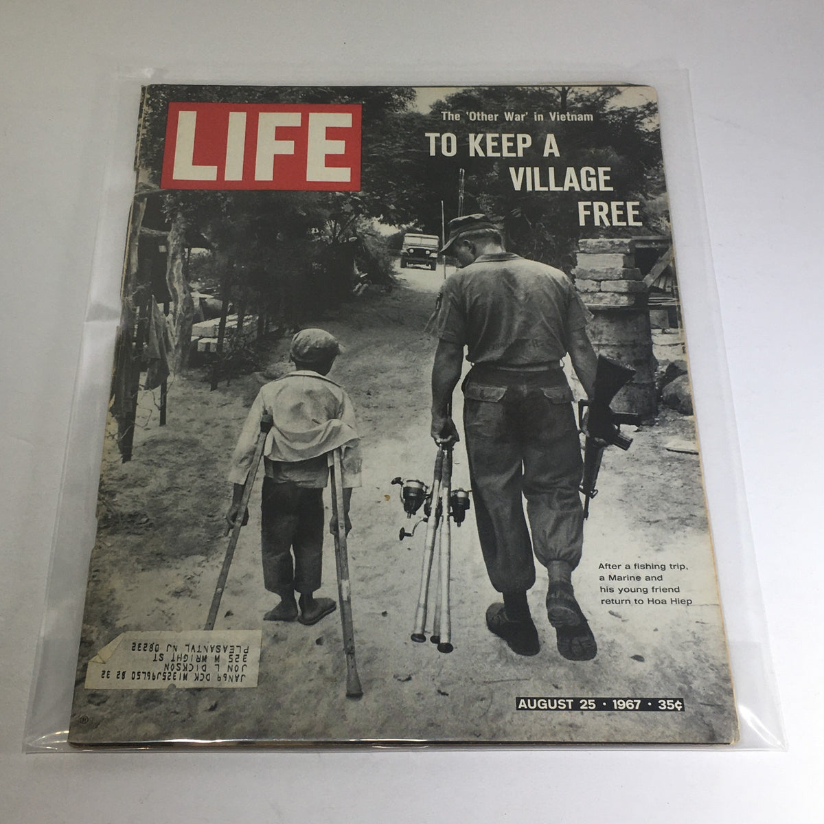 Cover of VTG Life Magazine dated August 25, 1967, featuring the title 'To Keep A Village Free in Vietnam Other War'. The image shows a Marine walking with a young boy on a dirt path, both with fishing gear, symbolizing themes of friendship and the impact of the Vietnam War.
