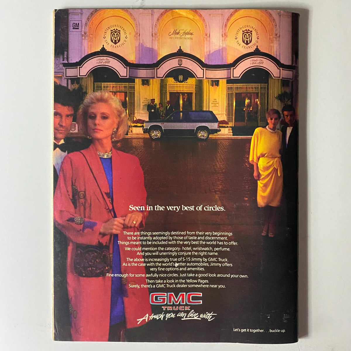 Back cover of Savvy Magazine October 1985 featuring an advertisement for GMC Truck. Evokes a luxurious lifestyle with stylish individuals in front of an upscale hotel, reflecting cultural trends of the 1980s.