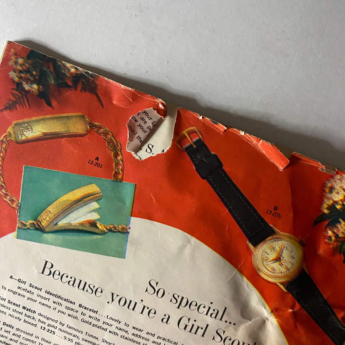 Close-up of the back cover of the Girl Scout Equipment Fall 1959 Spring 1960 Catalog showing detailed items like a bracelet and watch, illustrating the accessories available for Girl Scouts.