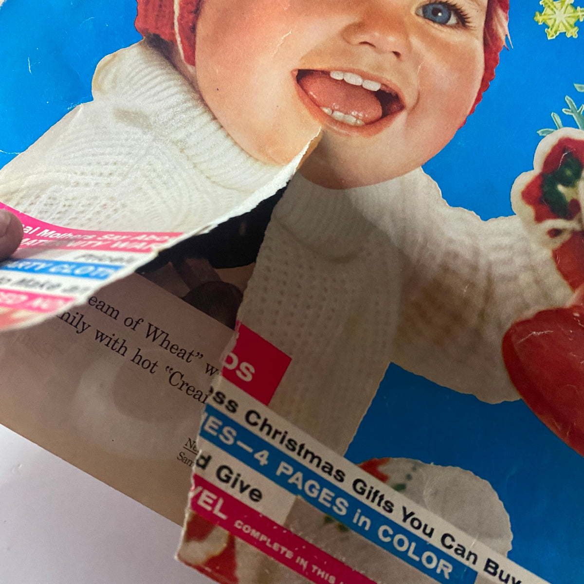 Close-up of the Ladies' Home Journal Magazine December 1958 cover highlighting a smiling baby in sweater and festive hat, emphasizing holiday themes and nostalgic design.