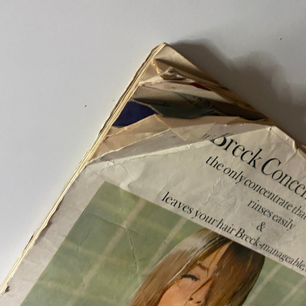 Close-up of a vintage advertisement for New Breck Concentrate Shampoo, illustrating its packaging and offering details on hair care benefits, part of a collectible 1960s magazine.
