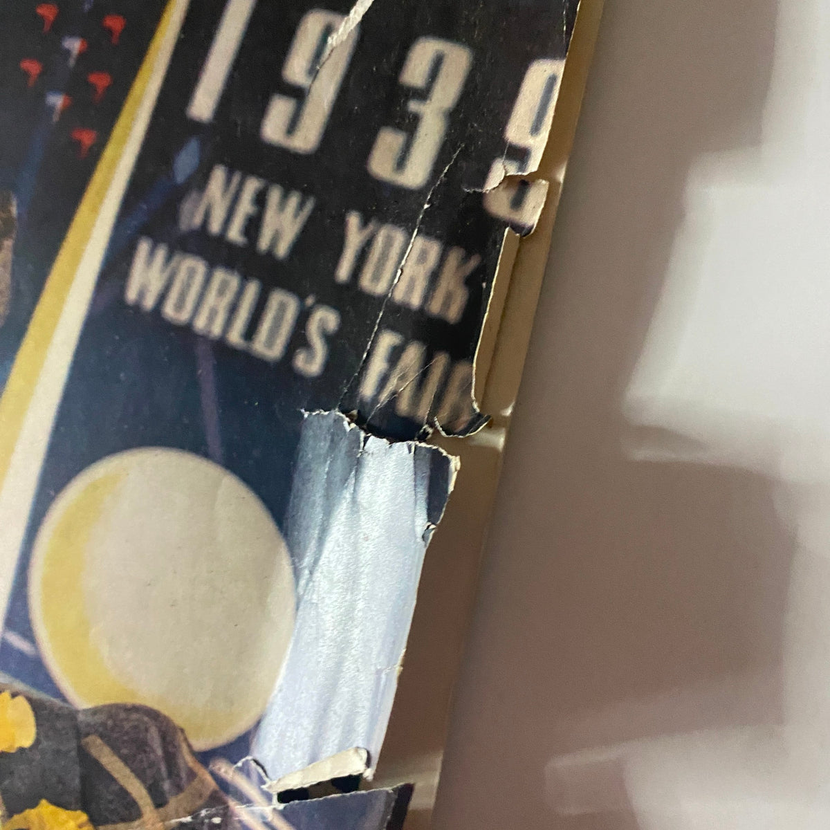 Close-up of the cover of McCall's Magazine March 1939 showing damaged edges, text about the New York World's Fair, and stylish 1930s design elements.