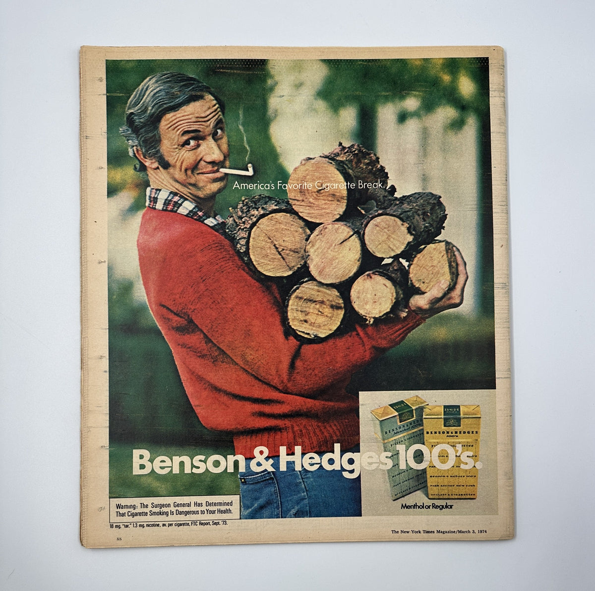 The New York Times Magazine March 3, 1974 featuring a vintage advertisement for Benson & Hedges 100s cigarettes, showcasing a smiling man carrying firewood, promoting the brand as America's favorite cigarette.