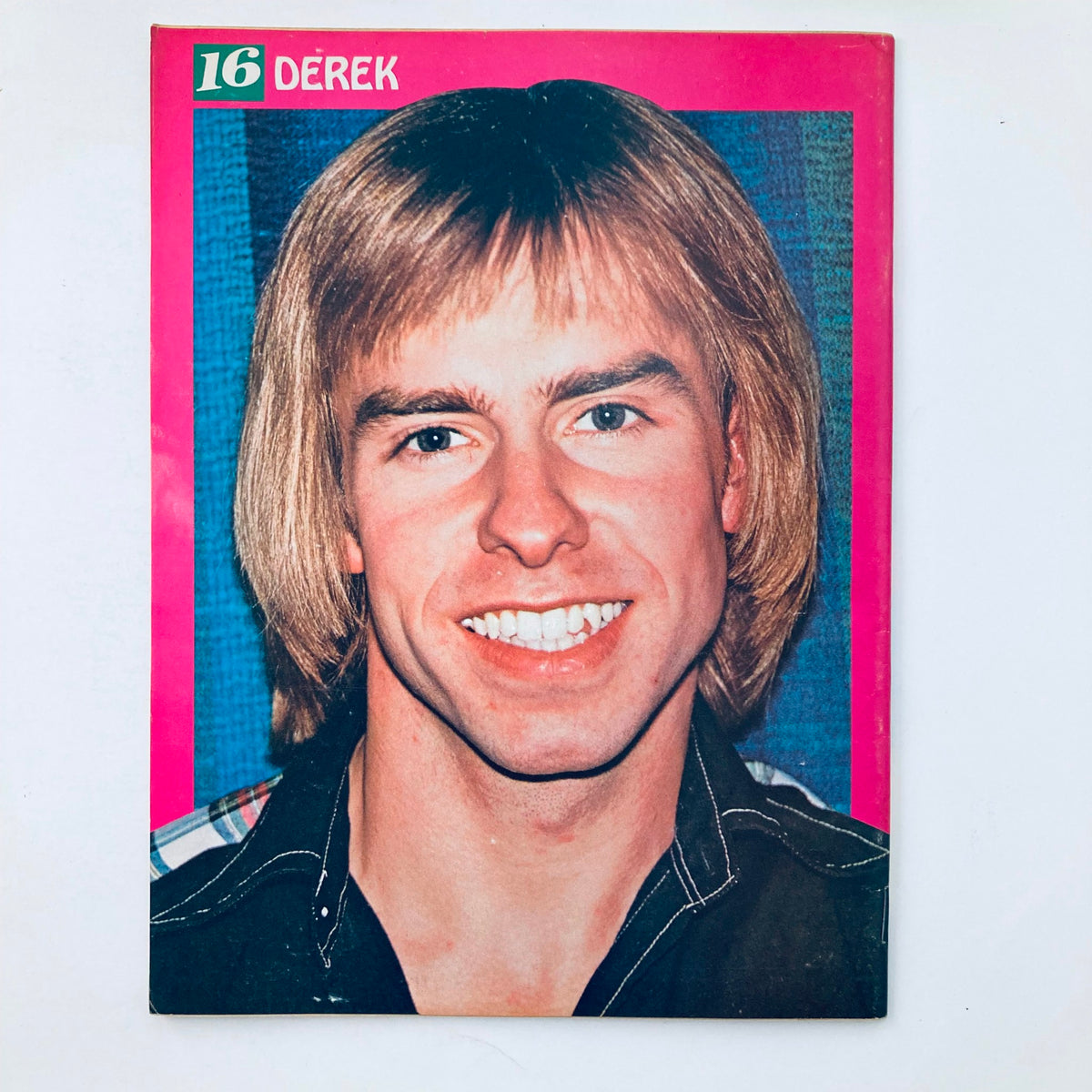 Featured photograph of Derek from the VTG 16 Magazine April 1977, with a bright pink border and smiling portrait of the pop star.