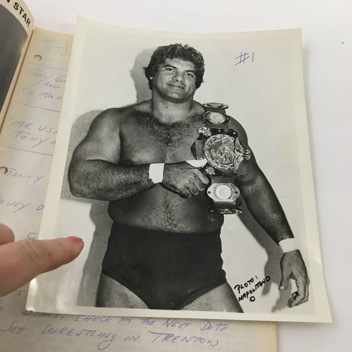 Inside the WWF Major League Wrestling Official Souvenir Program 1981 #139, a black-and-white photograph of a muscular wrestler holding championship belts, exemplifying the rich history of professional wrestling.