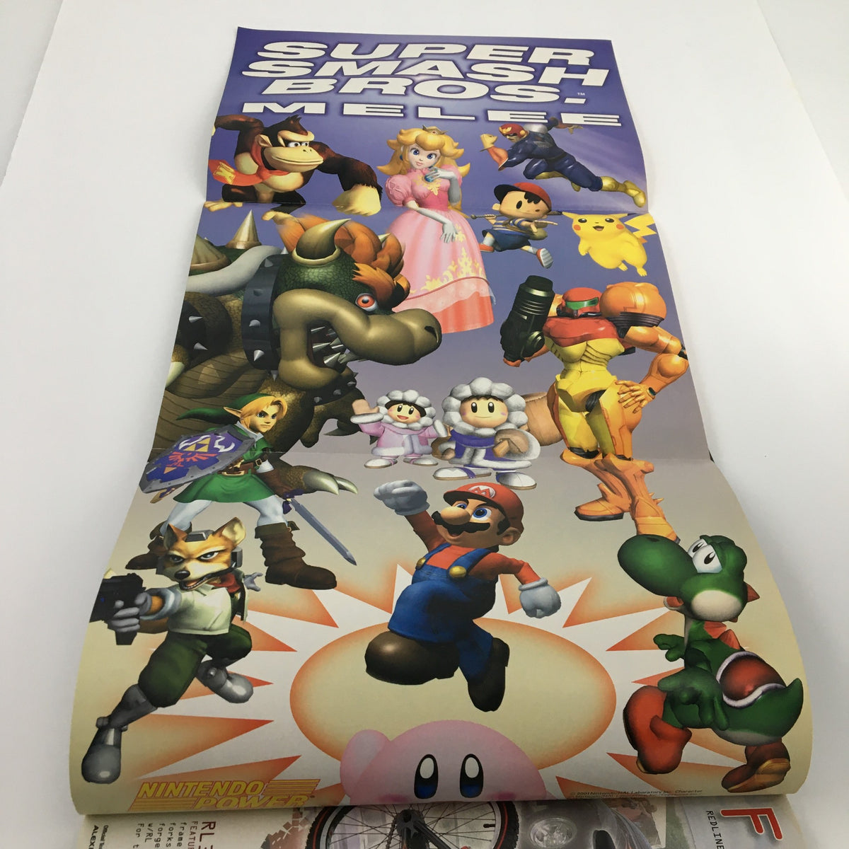 Poster from Nintendo Power Magazine November 2001 #150 featuring characters from Super Smash Bros. including Mario, Luigi, Princess Peach, and many others in a colorful display.