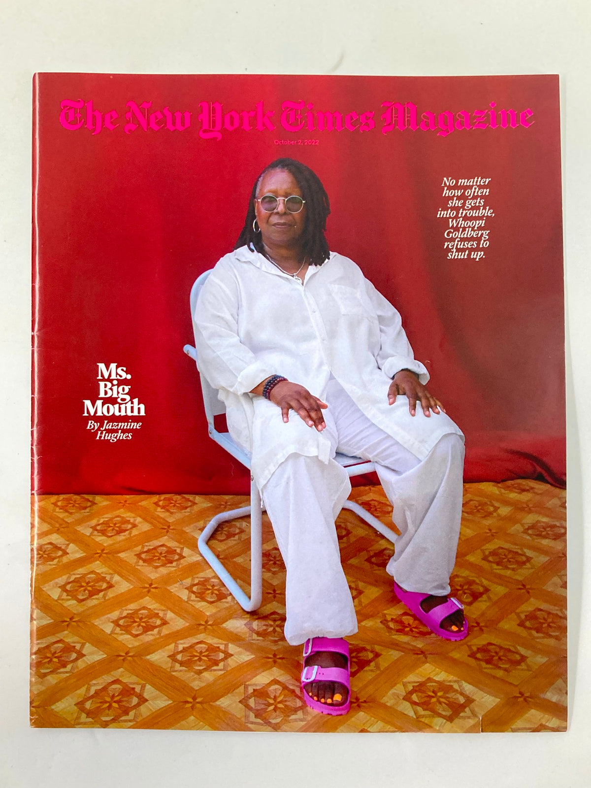 The New York Times Magazine October 2 2022 cover featuring Whoopi Goldberg seated in a white outfit with pink sandals, showcasing a bold and artistic design.