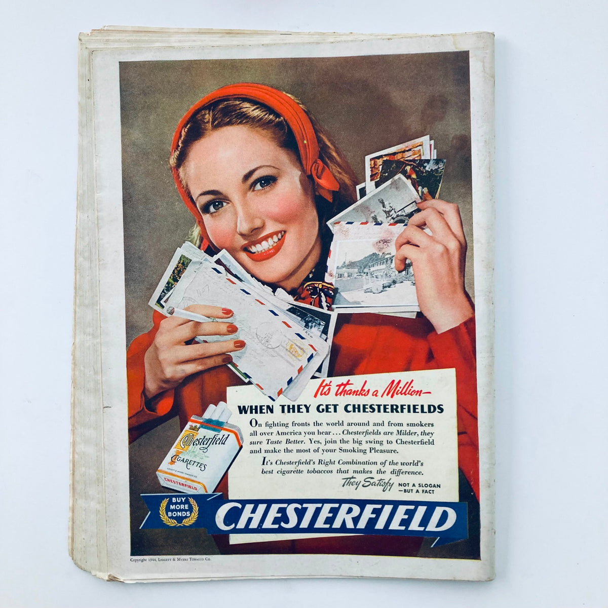 Back cover of the vintage Time Magazine from March 27, 1944 displaying an advertisement for Chesterfield cigarettes along with an image of a woman holding postcards.