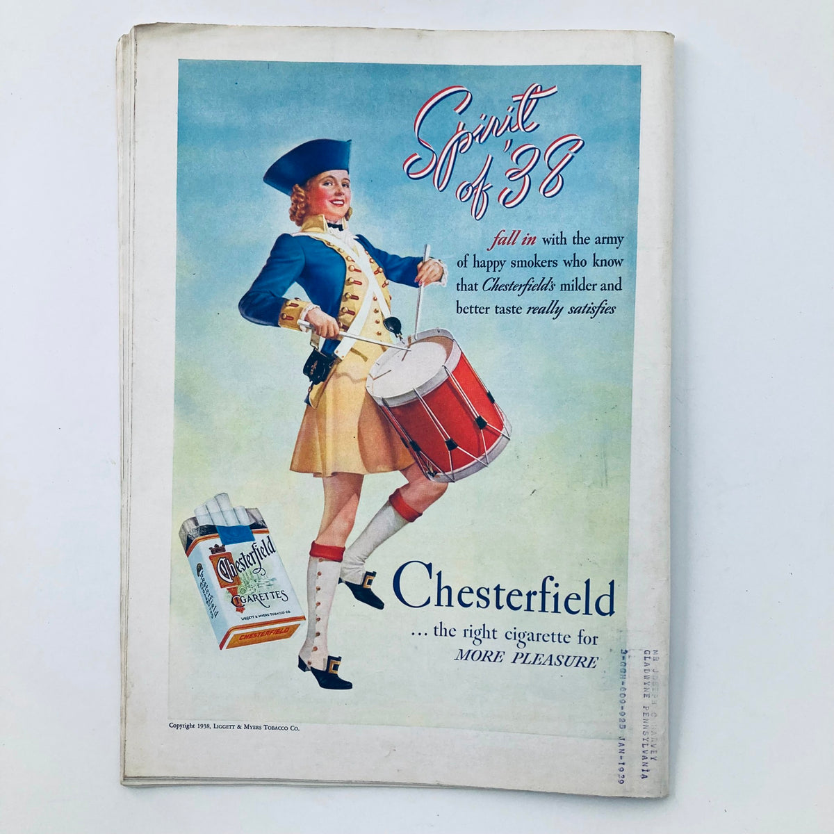 Chesterfield cigarette advertisement from a vintage magazine, promoting the 'Spirit of 38' with an illustration of a drummer girl in a historical costume.