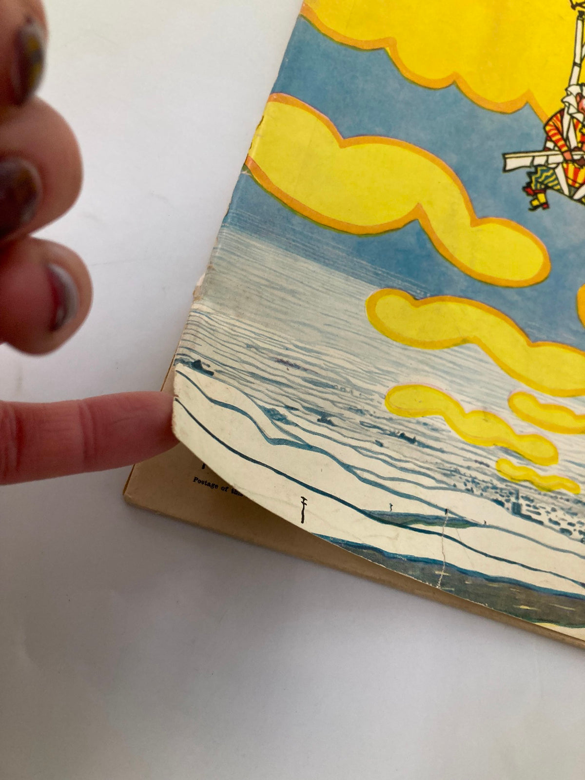 Detailed view of the edge of VTG Punch Magazine from November 5, 1951, showcasing minor wear with vibrant colors and artistic elements of clouds and sea.