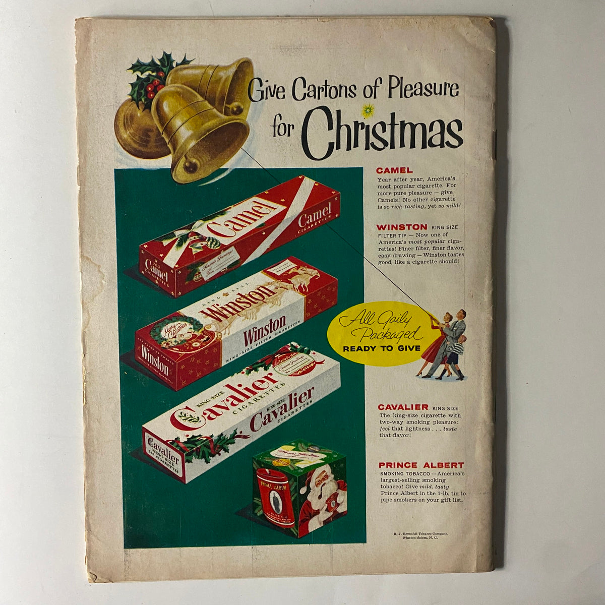 Advertisement from the back cover of The American Legion Magazine December 1955 promoting cigarette brands Camel, Winston, and Cavalier for Christmas gifting, showcasing colorful packaging and holiday themes.