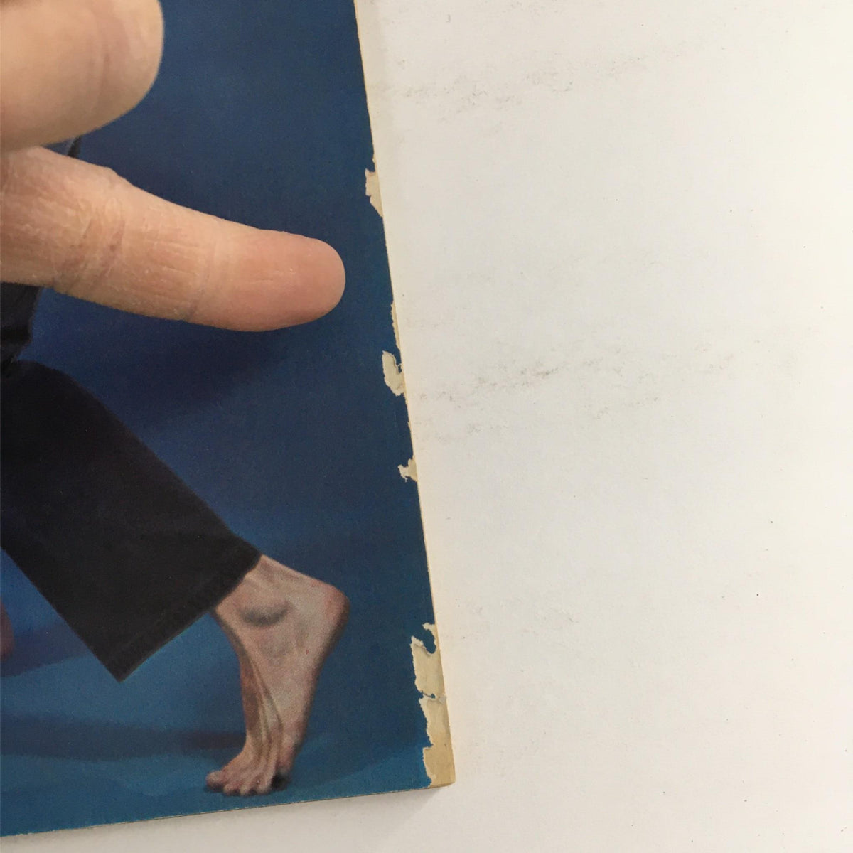 Close-up of a hand pointing to the edge of the Karate Illustrated Magazine from November 1978 featuring Cynthia Rothrock, showcasing wear on the magazine's cover.