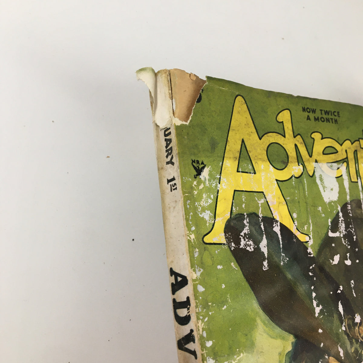 Close-up of the spine and corner of the Vintage Adventure Magazine from February 1, 1935, emphasizing the title 'VTG Adventure Magazine February 1 1935 Bristol, The Blunderer Novelette No Label' with visible wear and tear.