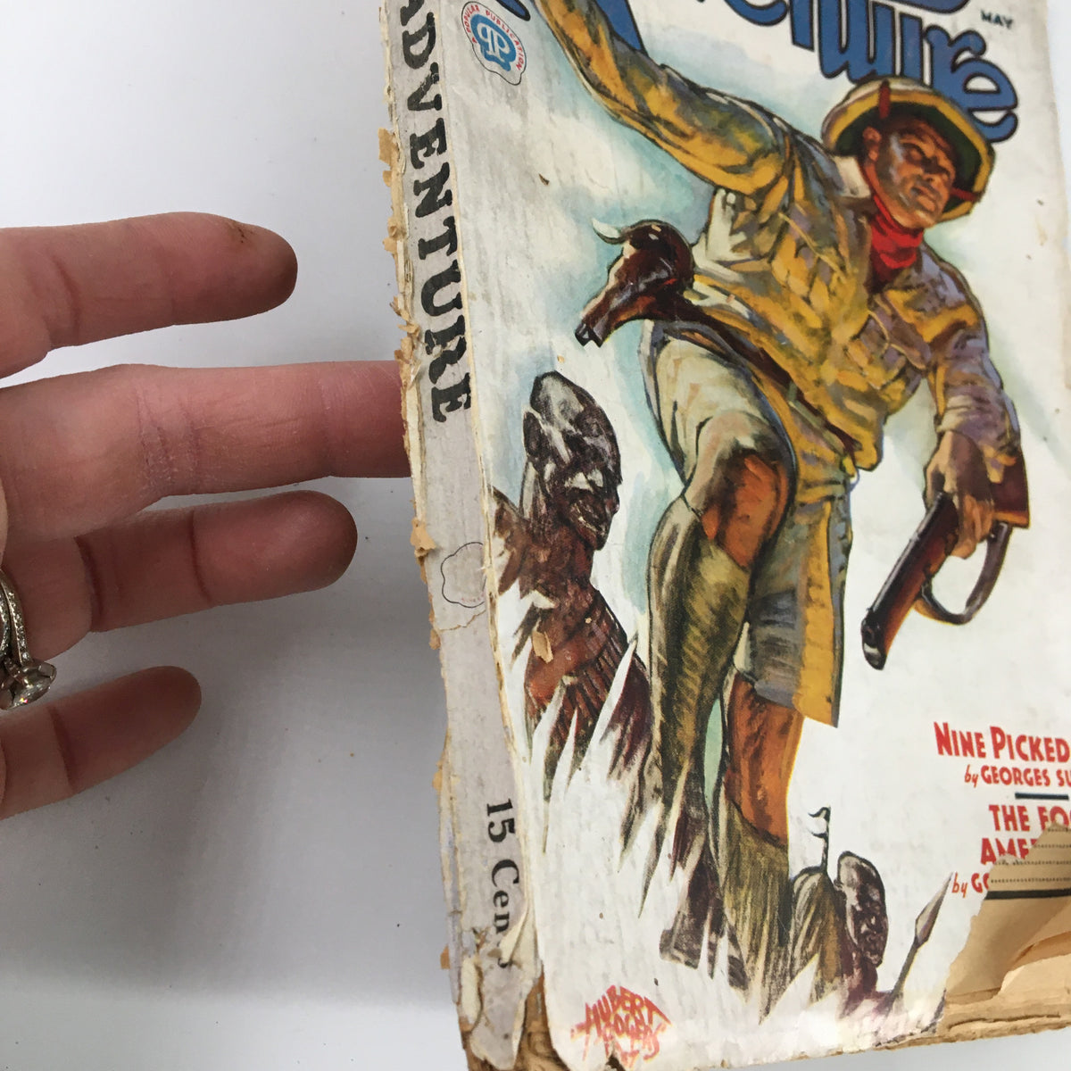 Side view of VTG Adventure Magazine May 1937 showcasing its worn edges and cover art depicting a soldier. The magazine highlights the story 'Nine Picked Men'.