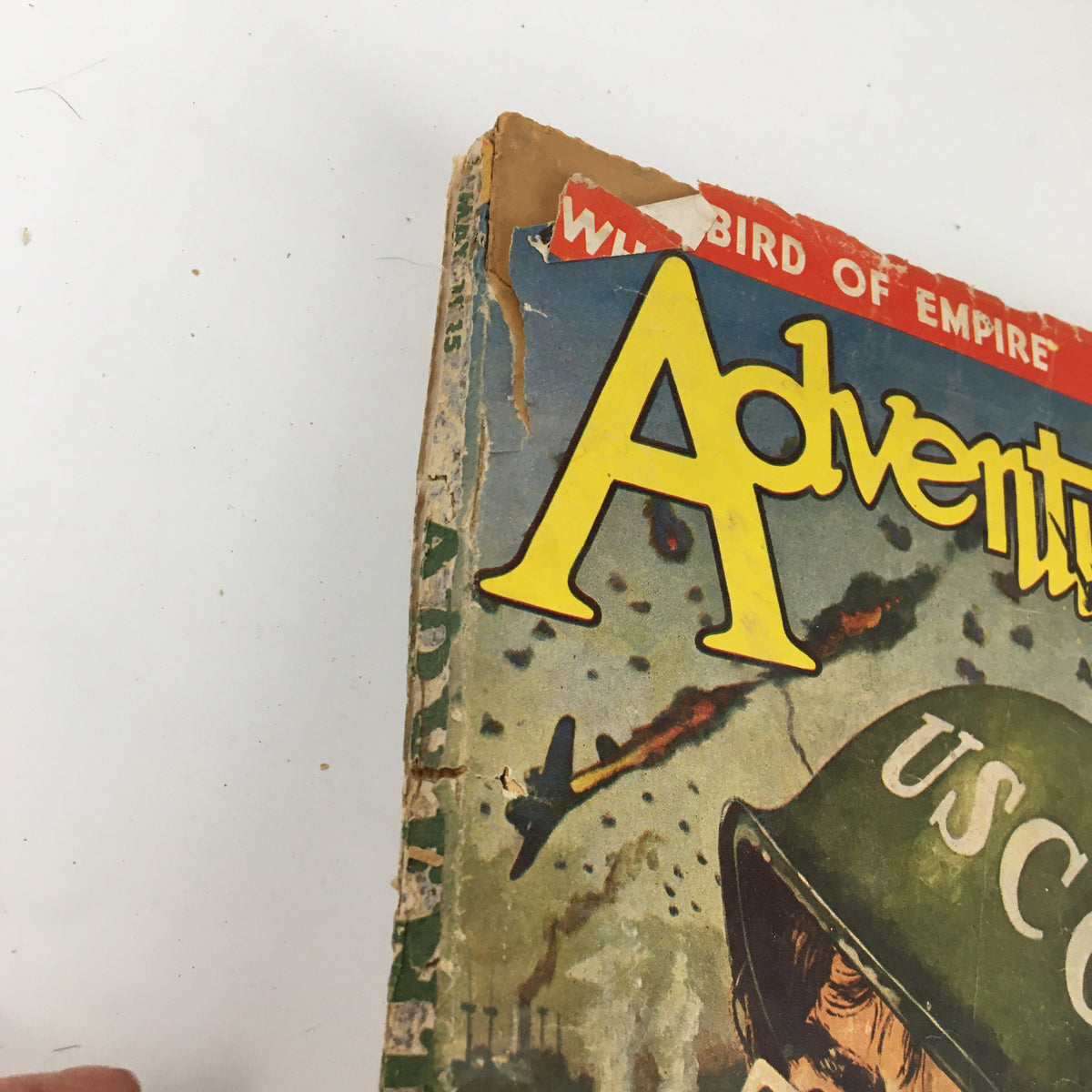 VTG Adventure Magazine May 1945 cover detail showcasing vintage pulp art with visible wear and tear, including a torn corner, representative of classic mid-20th century adventure storytelling.