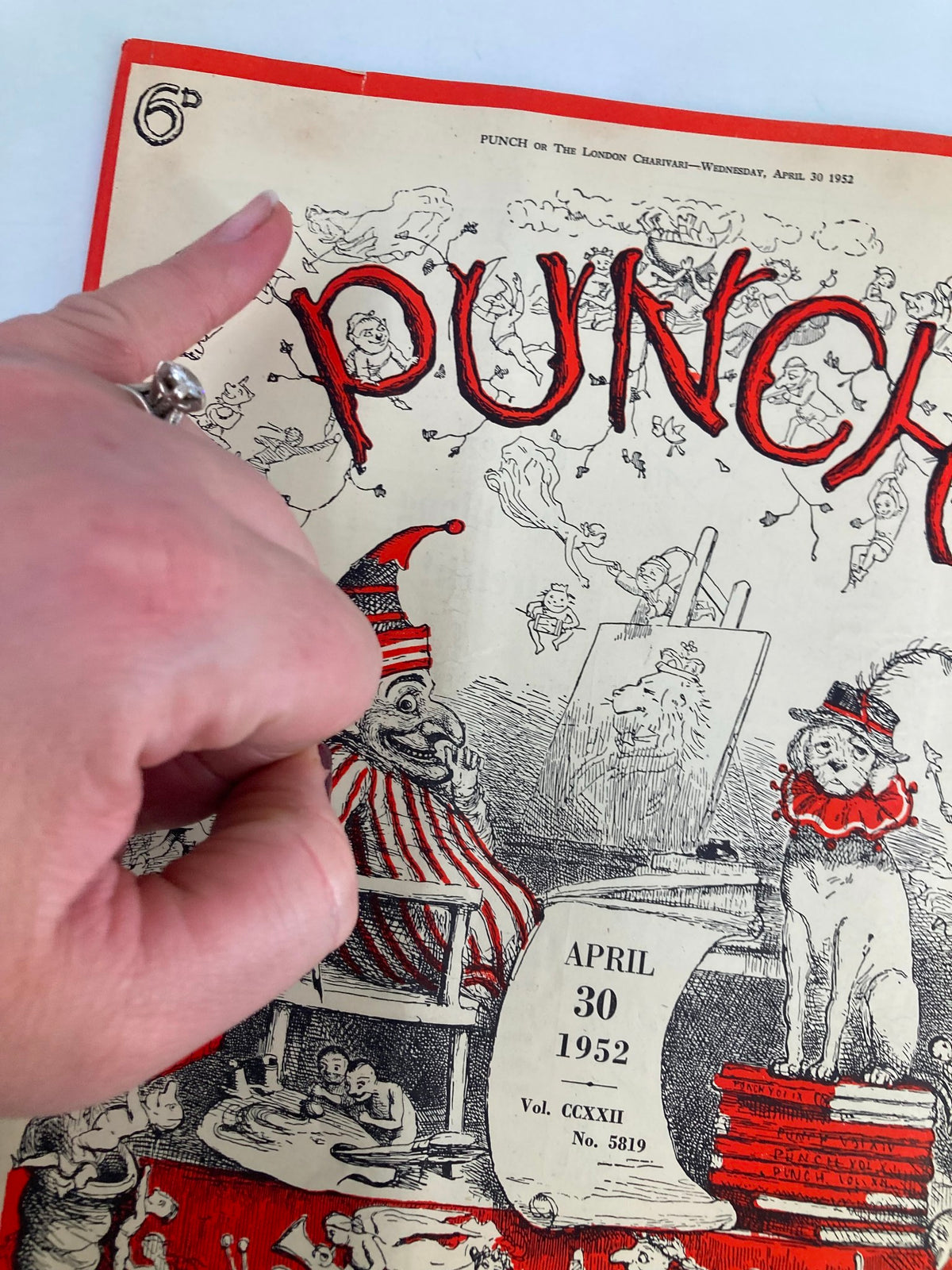 Close-up view of VTG Punch Magazine April 30 1952 cover highlighting playful artwork and its distinct title 'PUNCH' with a hand gesture for scale.