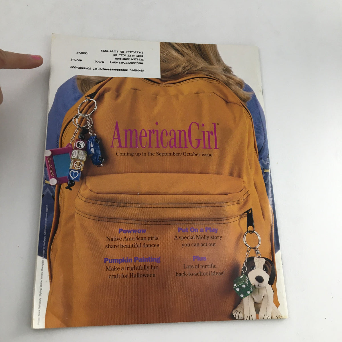 Cover of American Girl Magazine July-August 1999 featuring summer frosty treats, showcasing a yellow backpack with keychains, and highlights of the upcoming September/October issue.
