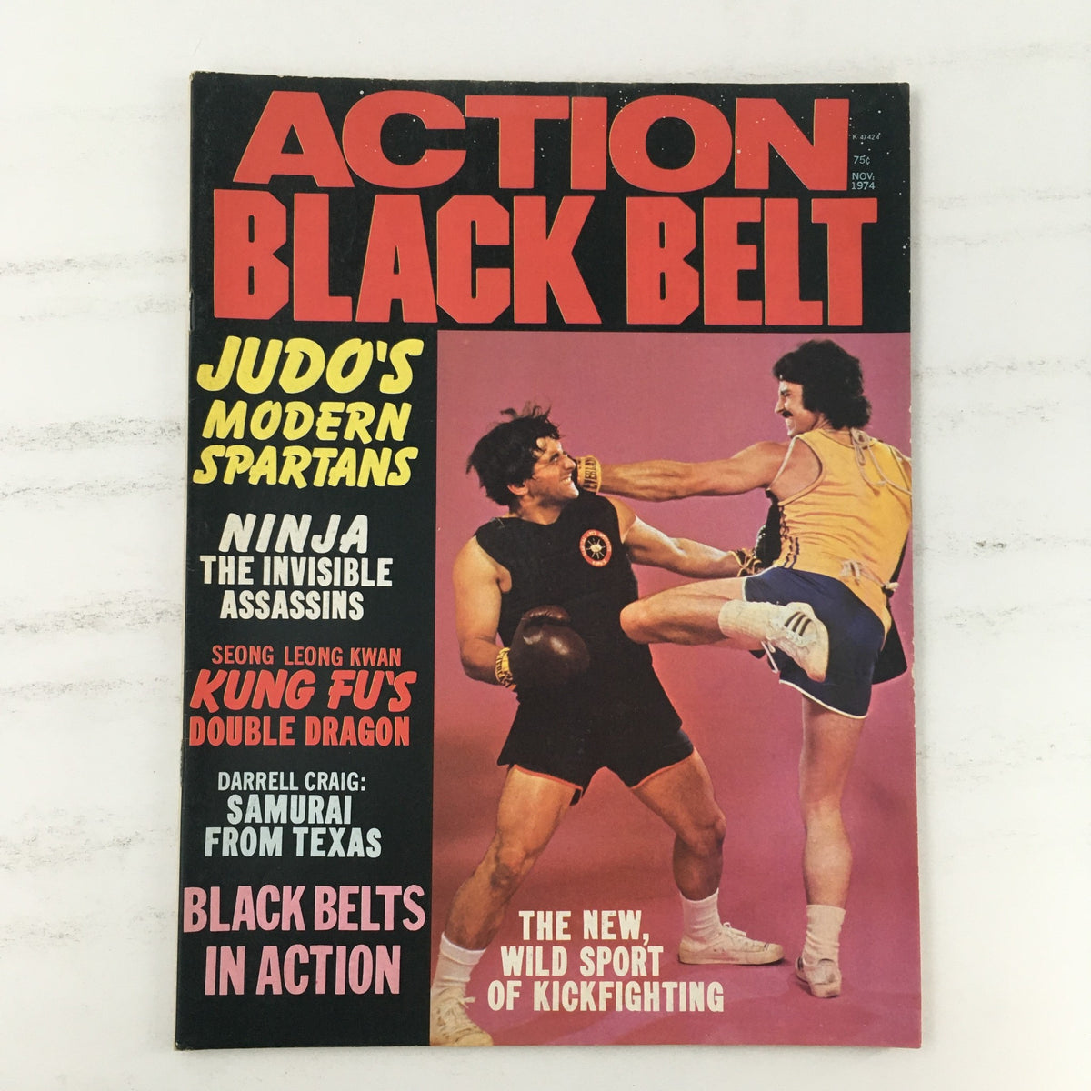 Cover of Action Black Belt Magazine, November 1974, Vol #1 #3, featuring articles on martial arts including 'Judo's Modern Spartans' and 'The New, Wild Sport of Kickfighting'. The cover showcases two male martial artists engaged in a dynamic kickboxing pose.