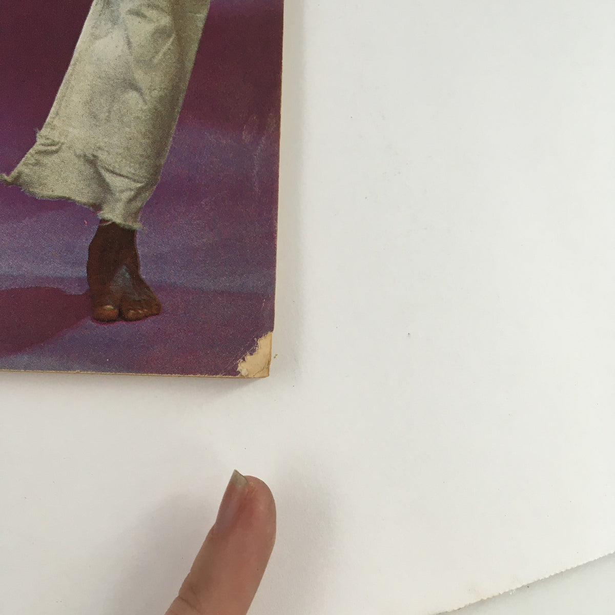 Detailed view of the edge of the Official Karate Magazine December 1975 Volume 7 Issue 54, highlighting slight creasing and wear, with a finger indicating the condition.