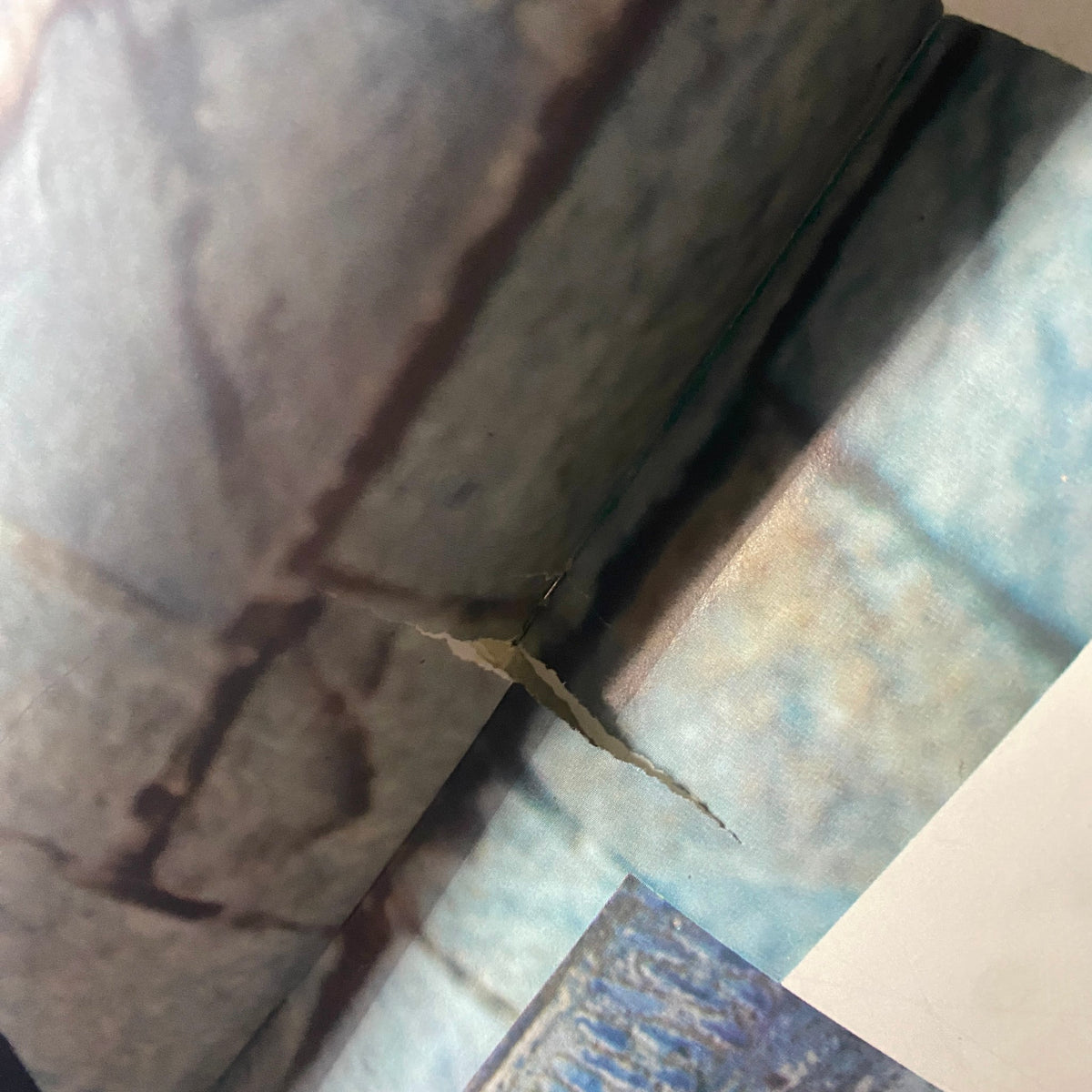 Close-up of wear and tear showing a tear on a page in the 1966 Columbia Minerva Bravo Mexico Knits Pattern Book.