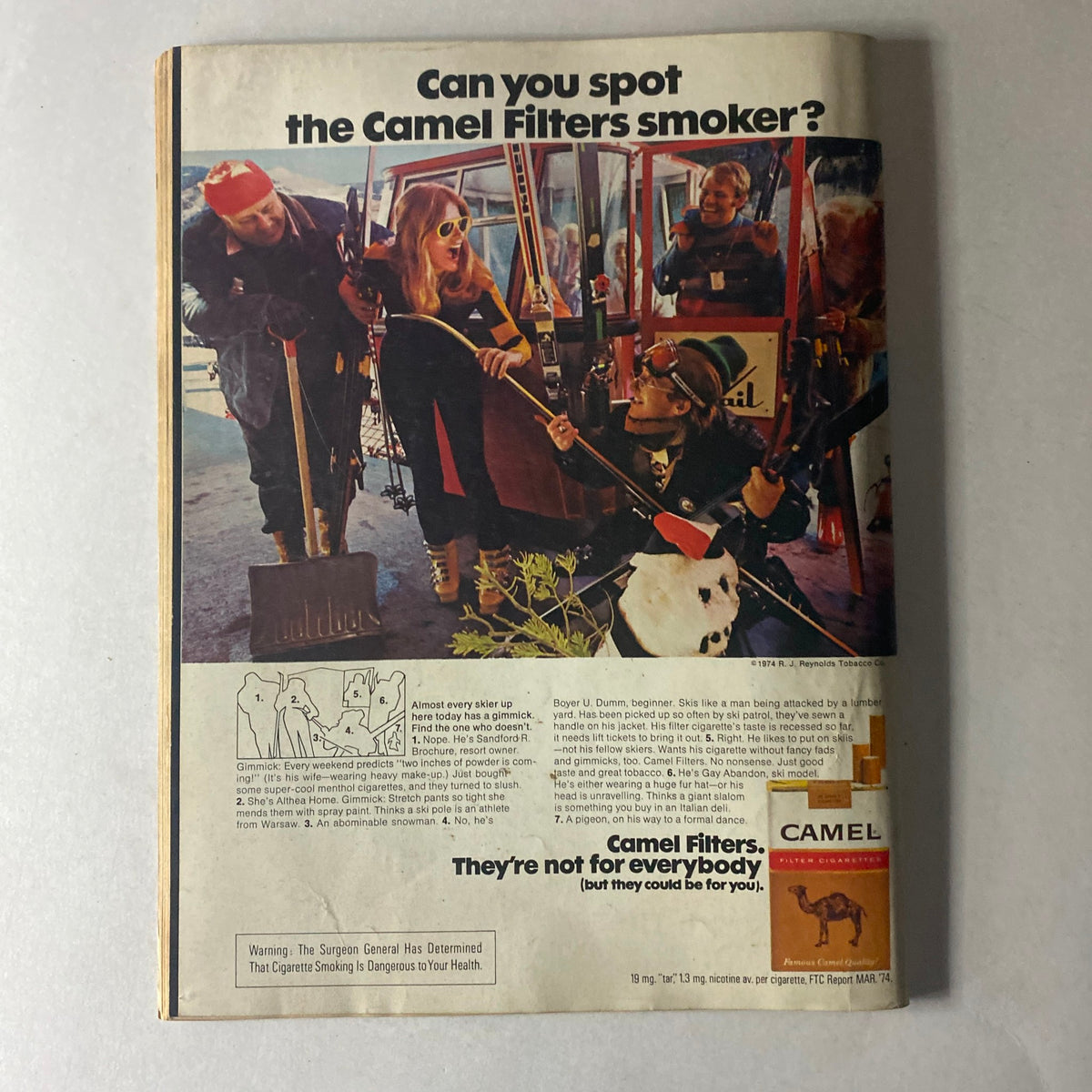 Cycle World Magazine February 1975 advertisement featuring Camel Filters, highlighting a group of skiers in a whimsical scene, promoting the brand's cigarettes.