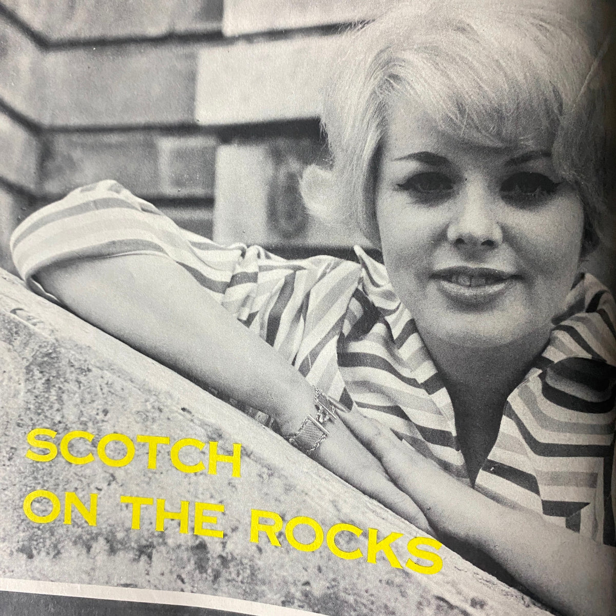 Image from Scene Magazine April 1962 featuring a young woman with blonde hair, captioned 'Scotch On The Rocks'.