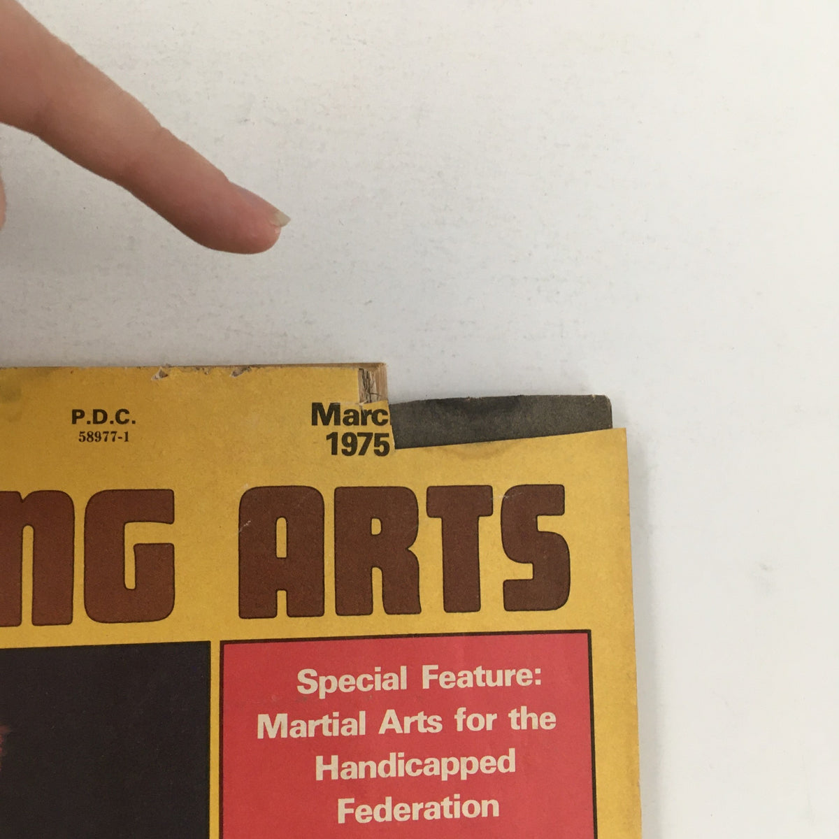 Close-up of the top corner of the Oriental Fighting Arts Magazine March 1975 Vol 1 #7 cover displaying the date and highlight on martial arts for the handicapped.