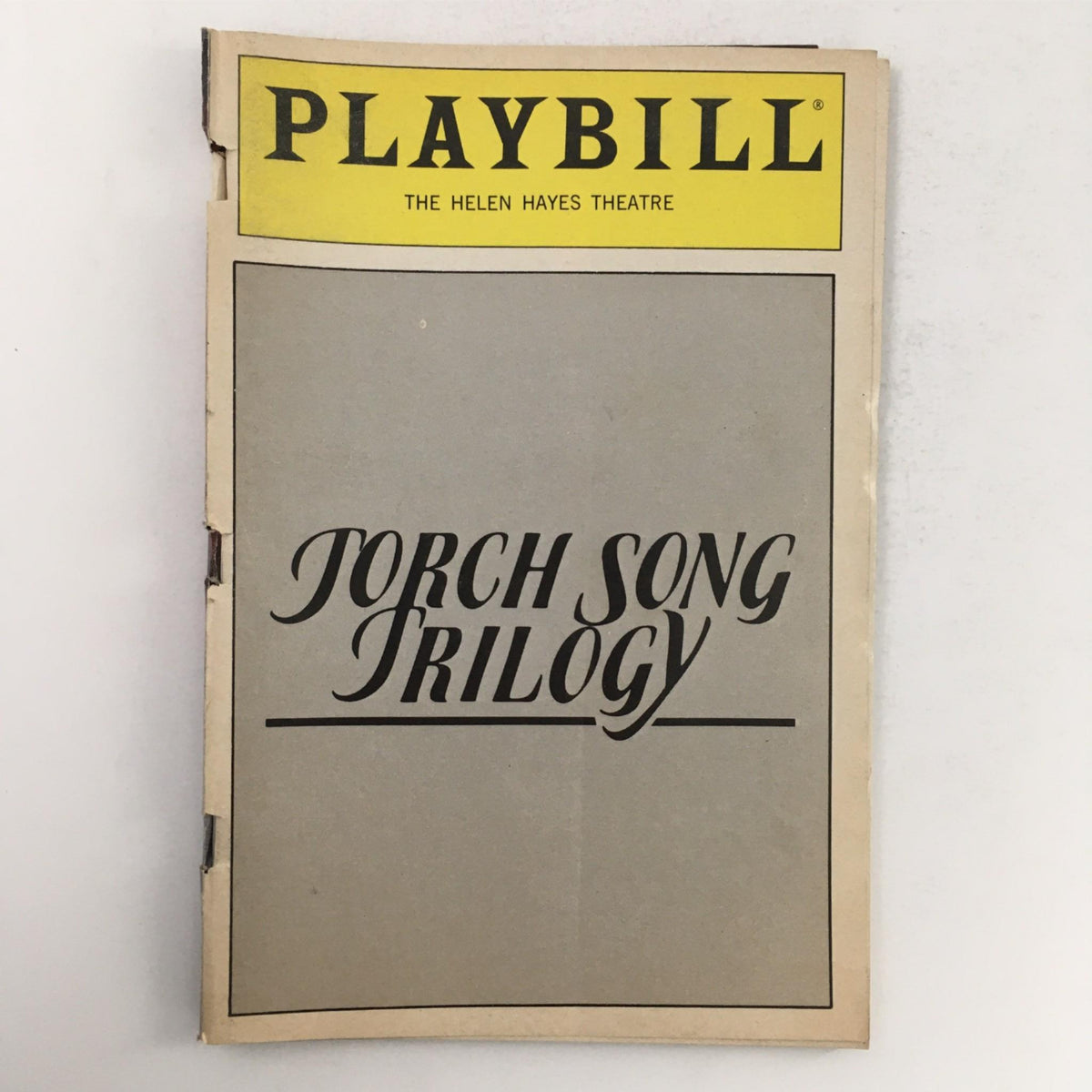 1983 Playbill for Torch Song Trilogy featuring the title prominently displayed, from The Helen Hayes Theater, showcasing a piece of theatrical memorabilia.