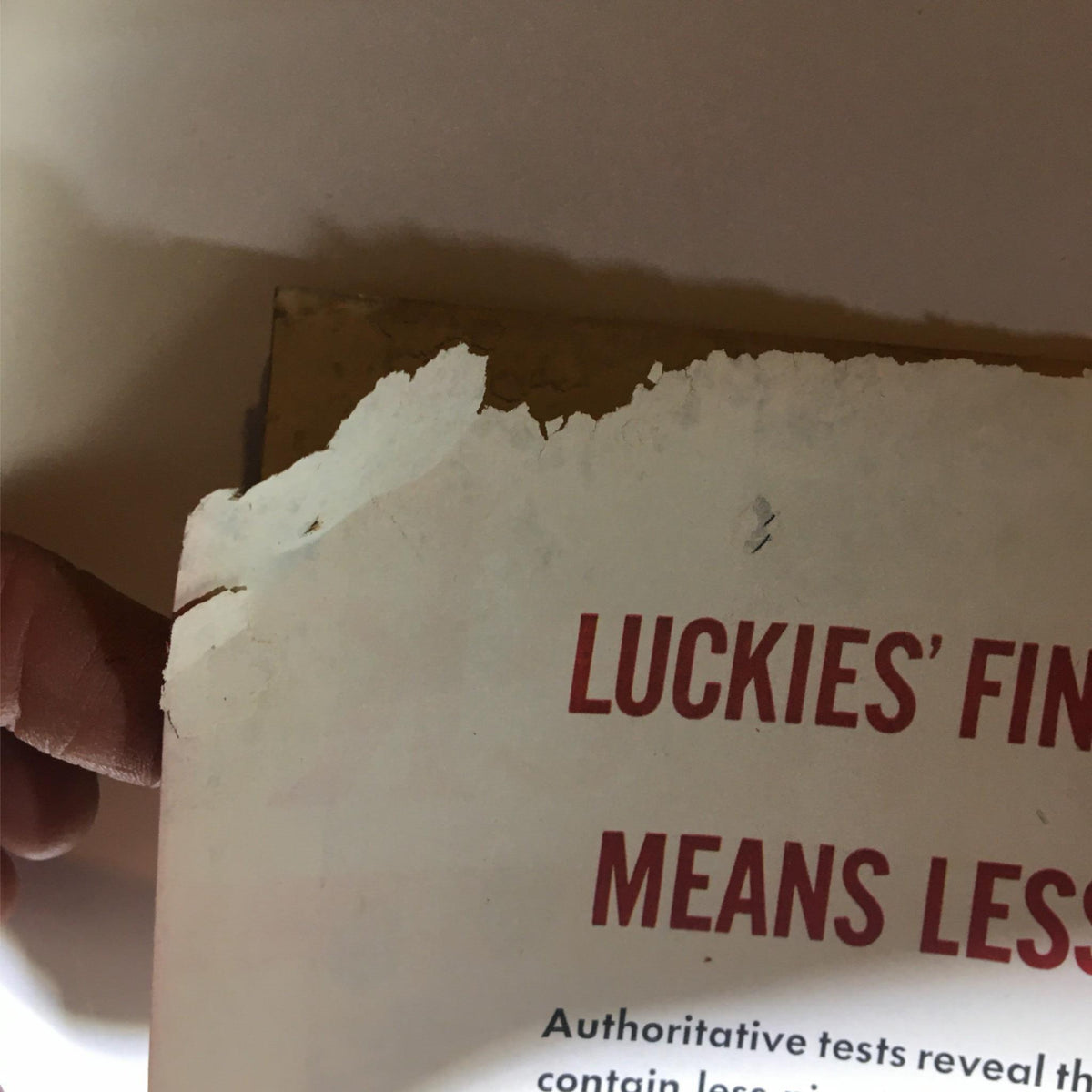 Close-up of the damaged back cover of Newsweek Magazine July 15, 1940, showing visible wear and tear with a label that reads 'Luckies' Finest Means Less.'