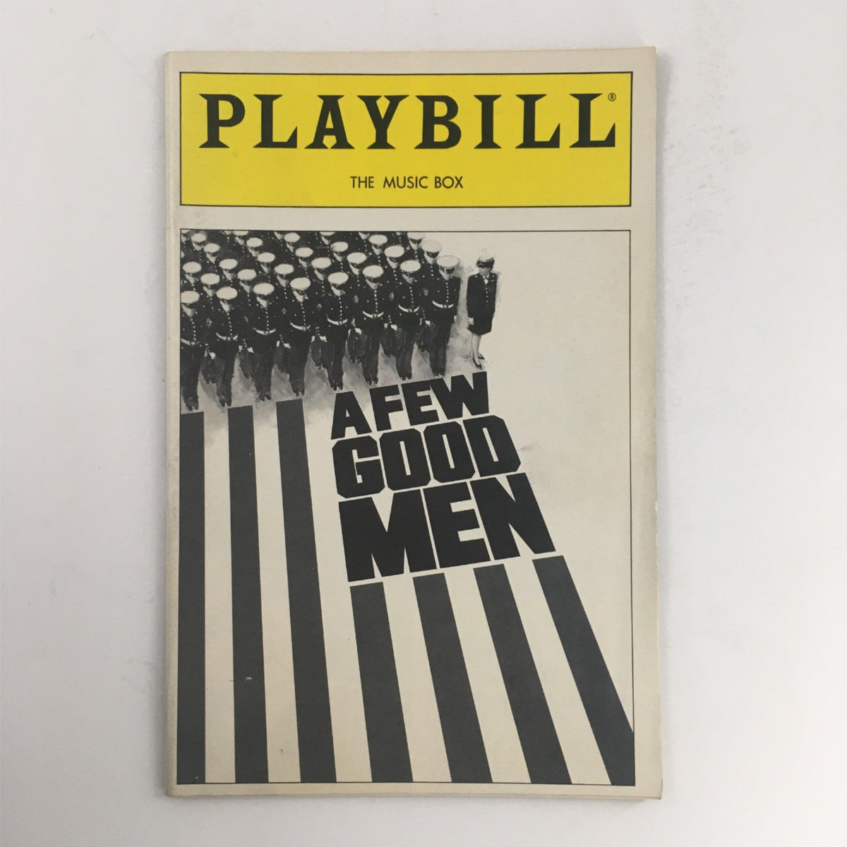 Cover of the 1990 Playbill for 'A Few Good Men' by Aaron Sorkin at The Music Box, featuring a striking black and white design with military theme.