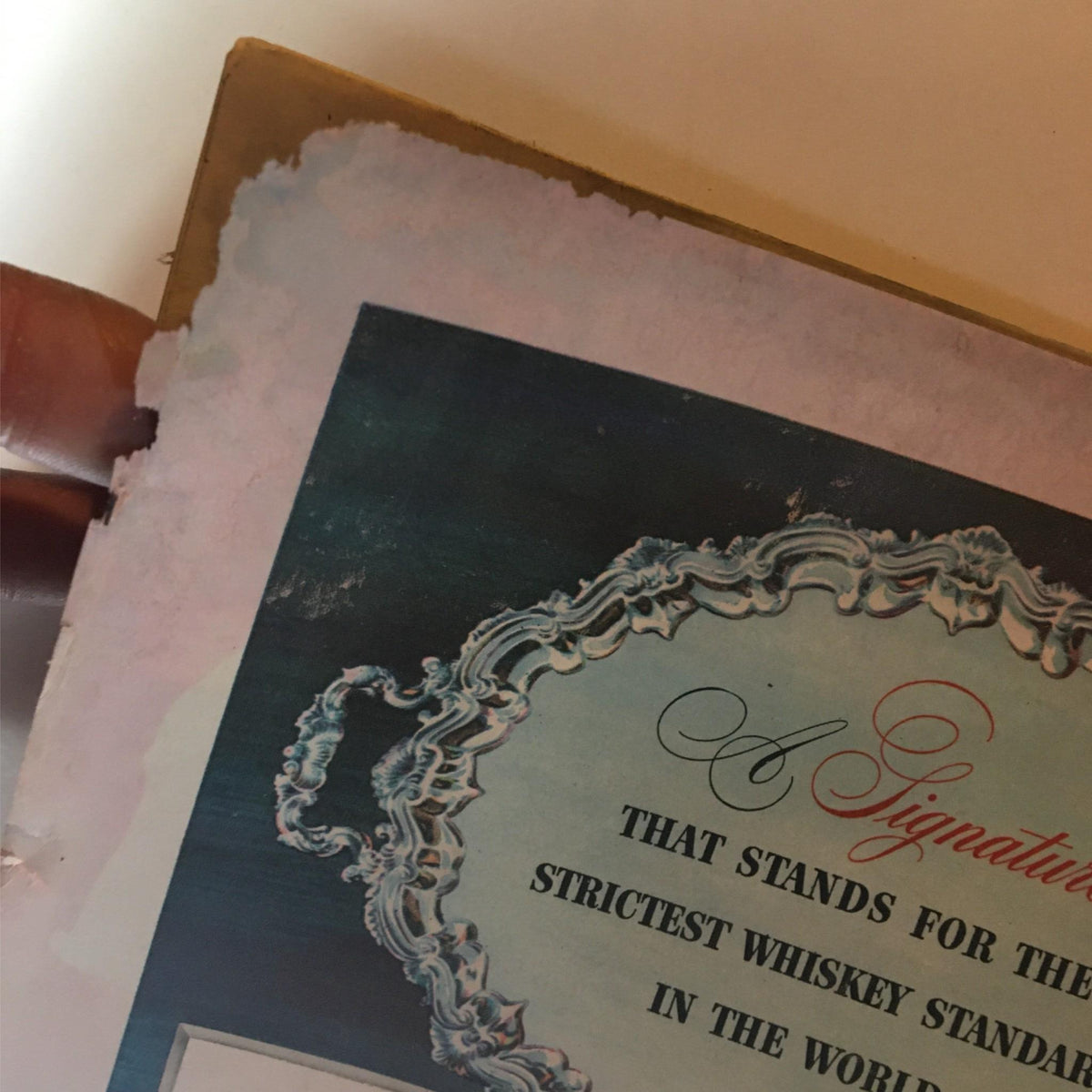 Top corner of the back cover of the June 15, 1942 Newsweek Magazine, featuring a damaged advertisement for Old Taylor whiskey.