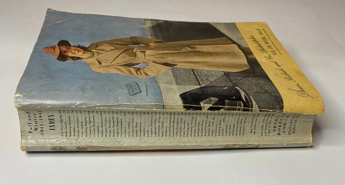 Side view of the 1941 - 1942 Sears Fall and Winter Catalog showing its spine and cover, highlighting the vintage design and condition.