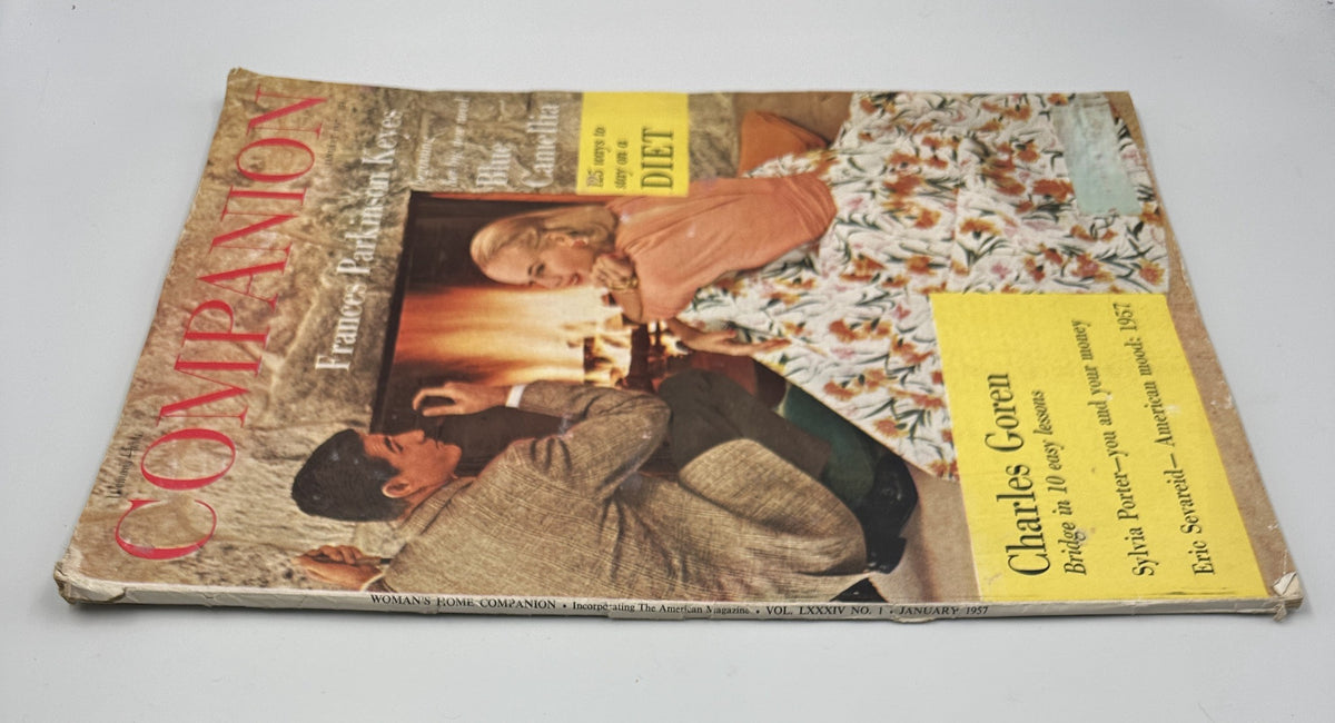 Side view of Woman’s Home Companion Magazine January 1957, showcasing the title Blue Camellia, with visible wear and tear, featuring articles on diet and finance by Sylvia Porter.