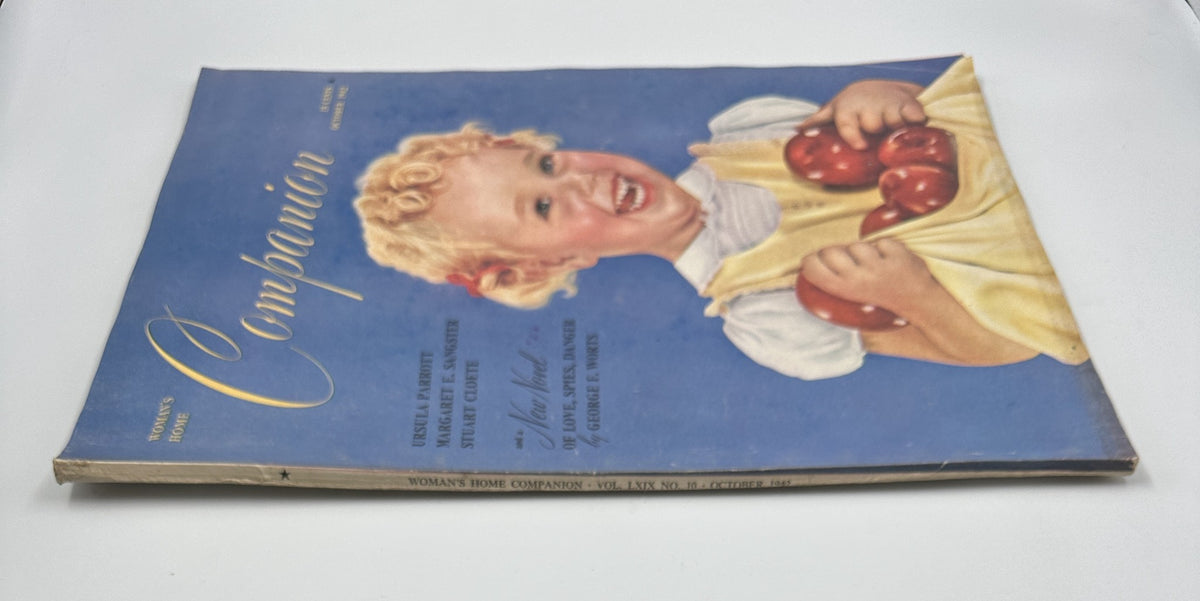 Cover of Woman’s Home Companion Magazine October 1942 featuring a cheerful girl holding red apples. The magazine reflects vintage design by George Worts with a colorful illustration.