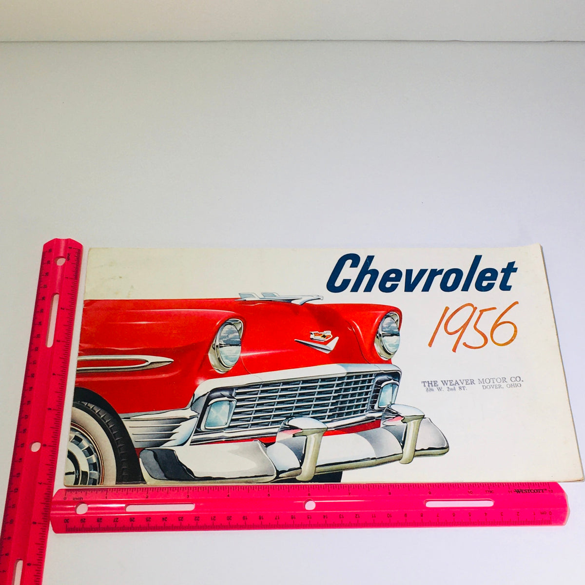 Front view illustration of a red Chevrolet car featured on the 1956 Chevrolet brochure, including the title 'Chevrolet 1956' and the Weaver Motor Co. address.
