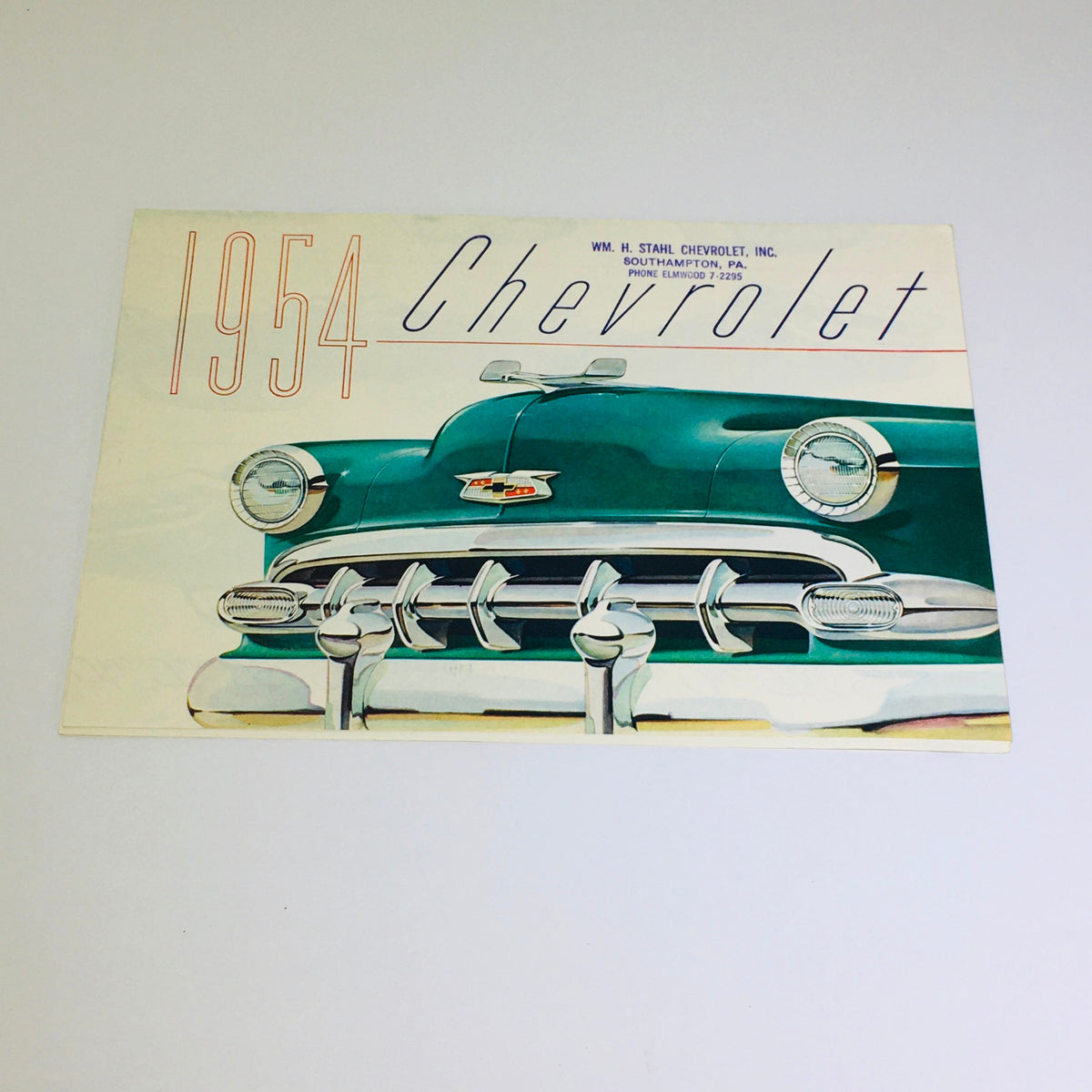 Cover of the Vintage 1954 Chevrolet Bel-Air 4-Door Sedan Blue-Flame 125 Engine Car Brochure featuring an artistic depiction of the car's front grille and emblem.
